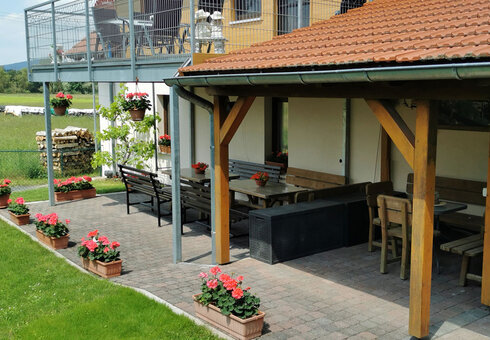 große Sitzecke mit Grillbereich unter dem Balkon