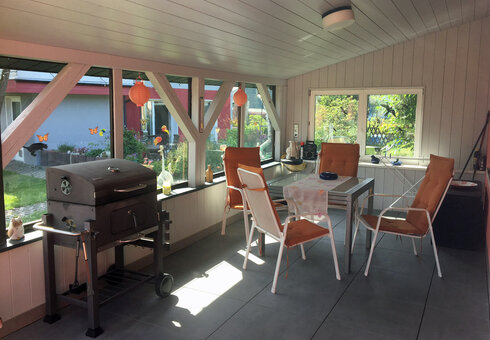 überdachte Terrasse mit Gartenmöbeln