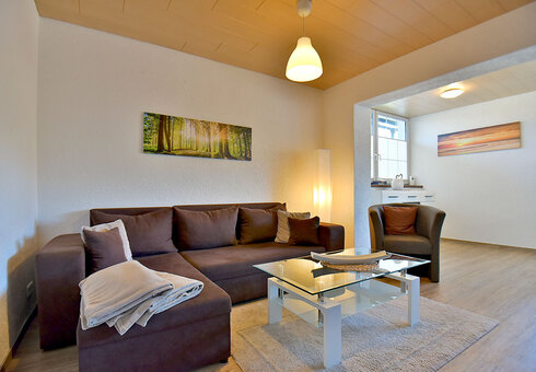 Wohnzimmer mit Couch, Kamin und TV