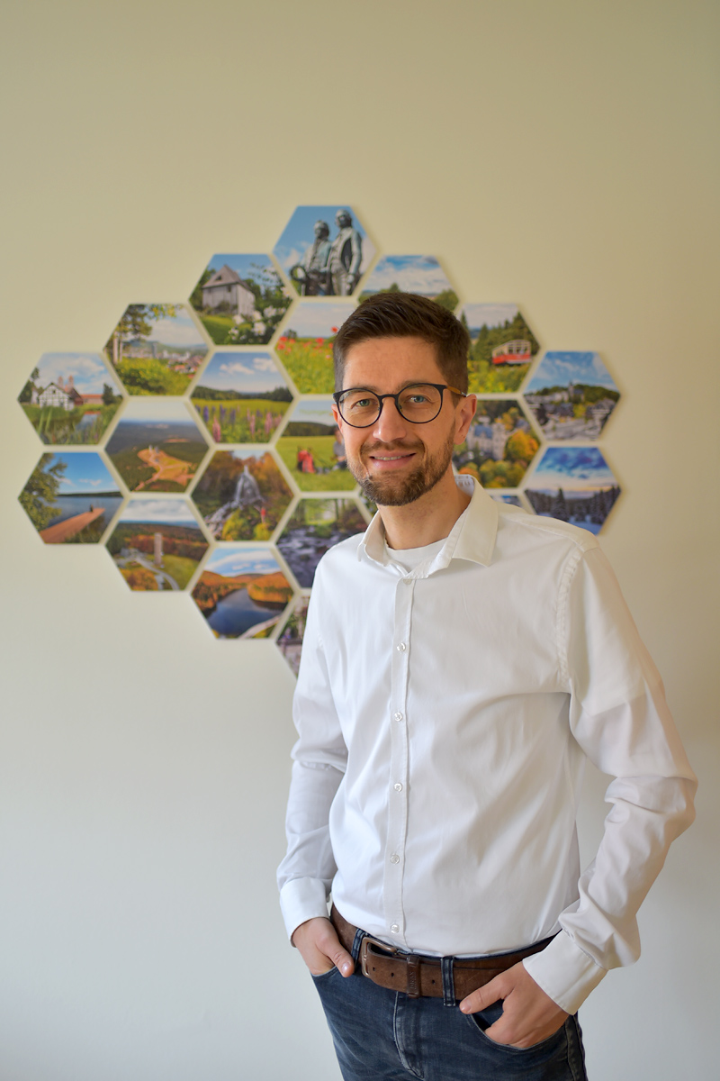 Henry Czauderna vor Fotowand im Büro