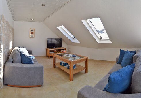 Wohnzimmer mit Couch und TV