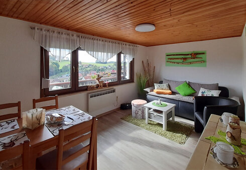 Wohnzimmer mit Couch und Esstisch
