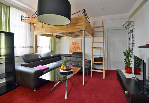 Wohnzimmer mit Couch, Ofen und TV