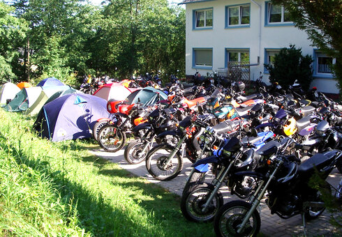 Zelte und Motorräder vor dem Haus