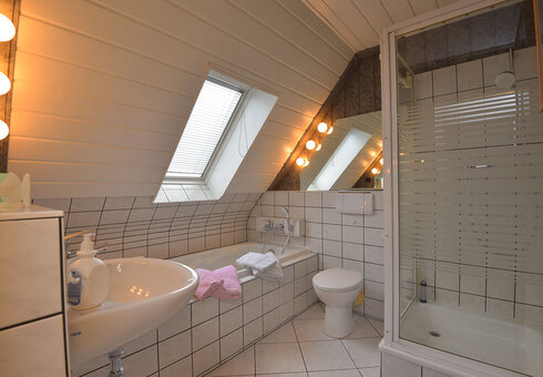 Badezimmer mit Badewanne und Dusche