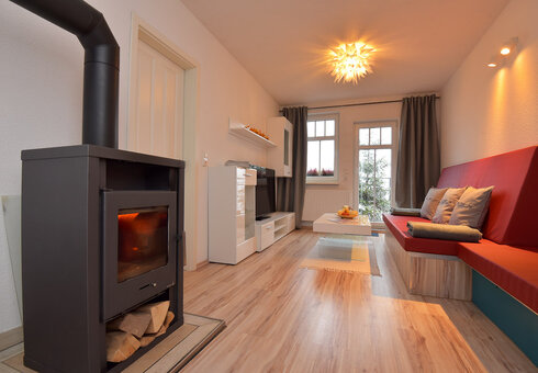 Wohnzimmer mit Couch, Kamin und TV