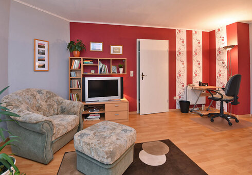 Wohnzimmer mit Chouch und TV