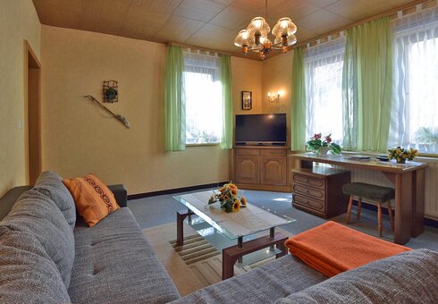Wohnzimmer mit Schreibtisch und TV