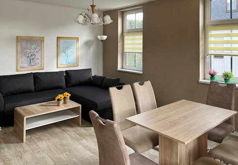 Wohnzimmer mit Couch und Esstisch