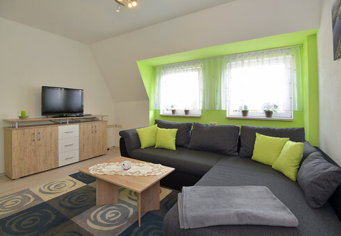 Wohnzimmer mit Couch und TV