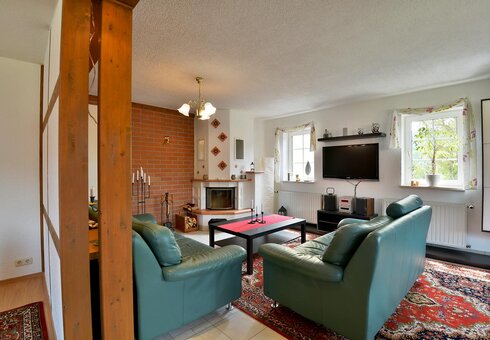 Wohnzimmer mit Couch, Kamin und TV