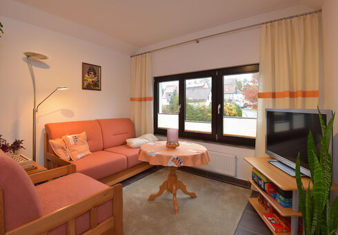 Wohnzimmer mit Couch und TV