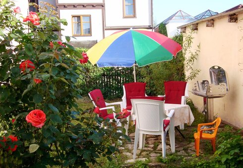 Terrasse mit Gartenmöbeln und Grill