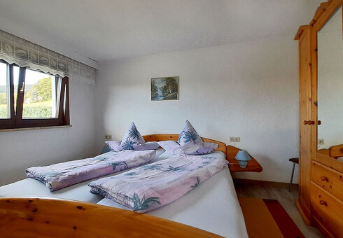 Schlafzimmer mit Doppelbett und Schrank