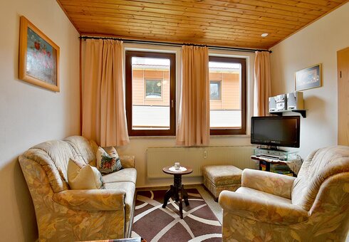 Wohnzimmer mit Couch und TV