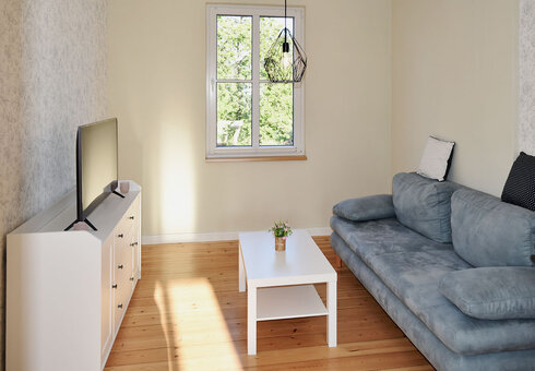 Wohnzimmer mit Couch und TV