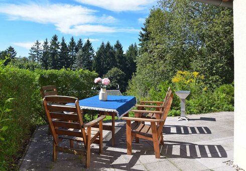 Terrasse mit Gartenmöbeln und Grill